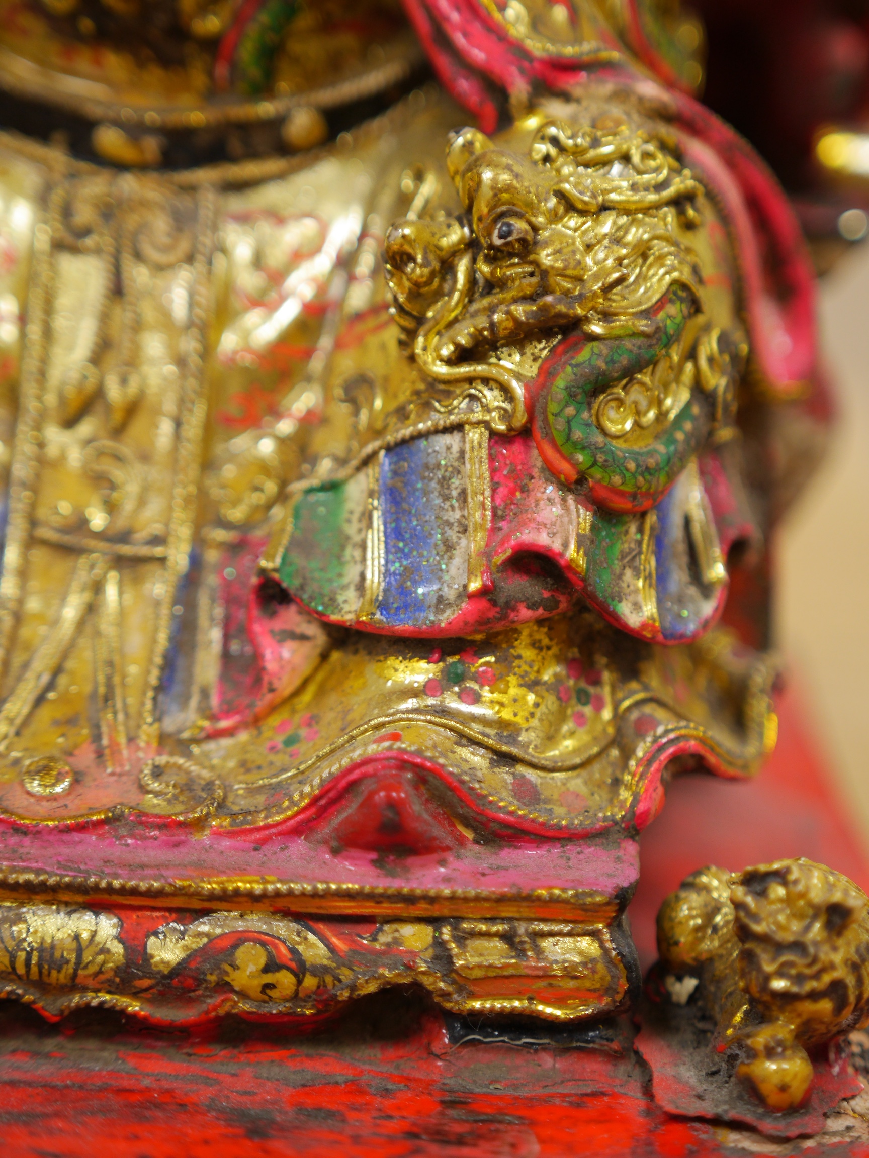 A Chinese gilt and painted composition figure of a seated immortal, 31cm tall. Condition - poor to fair